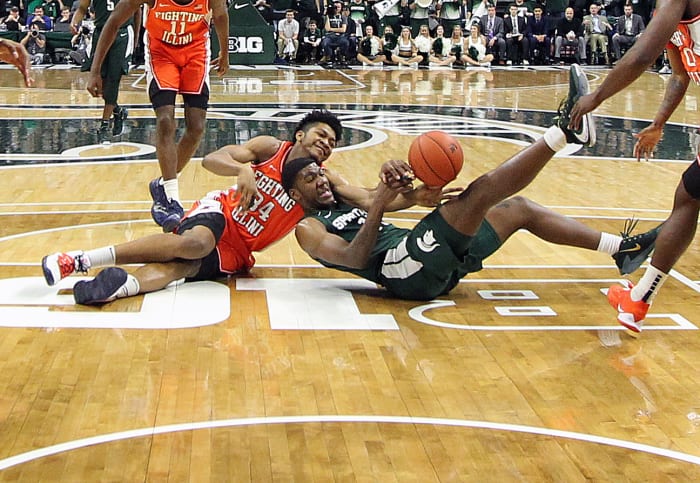Illinois Fighting Illini center Jermaine Hamlin (34) and Michigan State Spartans forward Aaron Henry (11) fight for a loose ball during the second half of a 2020 game at the Breslin Center.